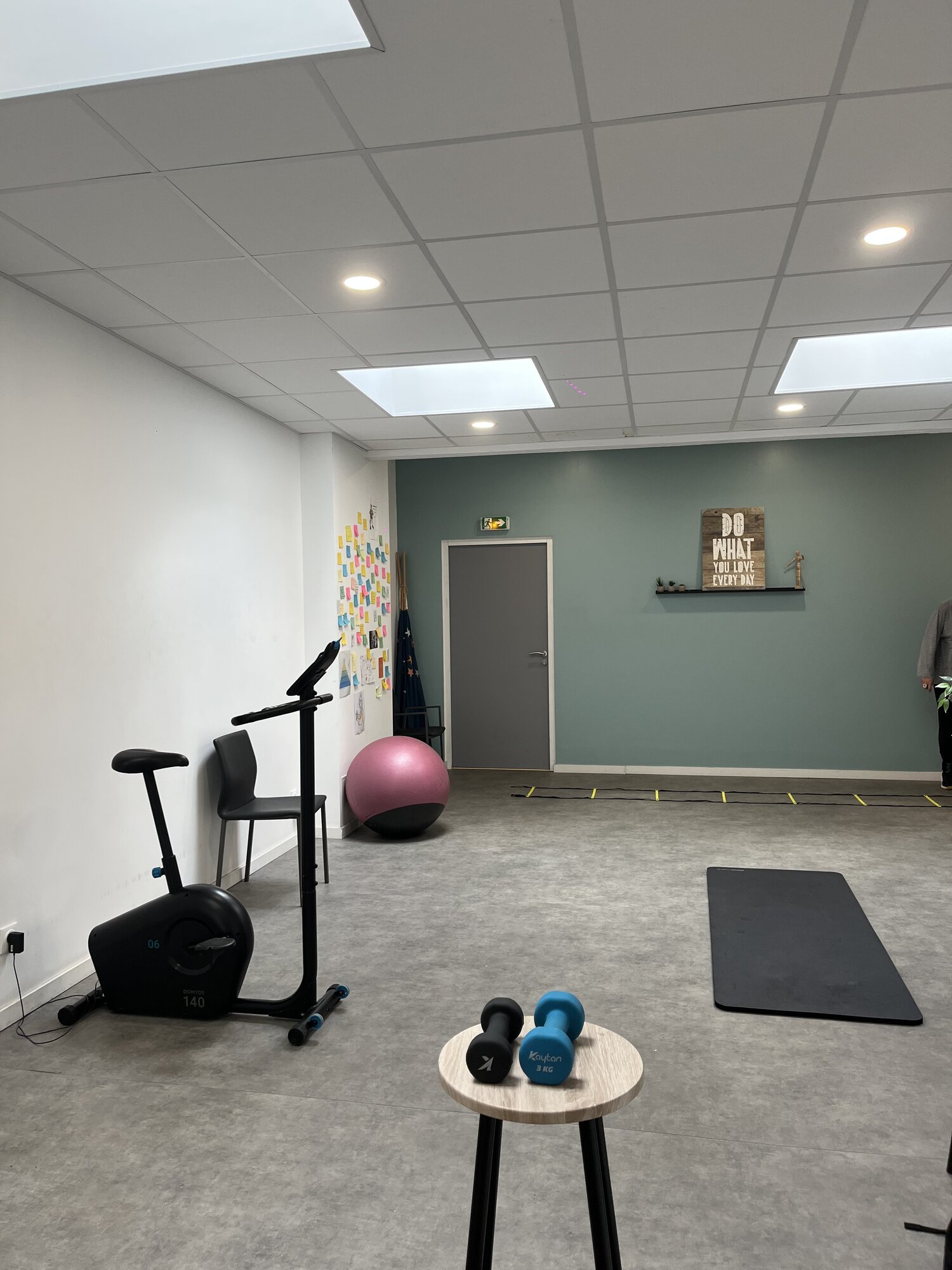 Espace d'exercice du cabinet avec vélo, ballon de gainage et tapis