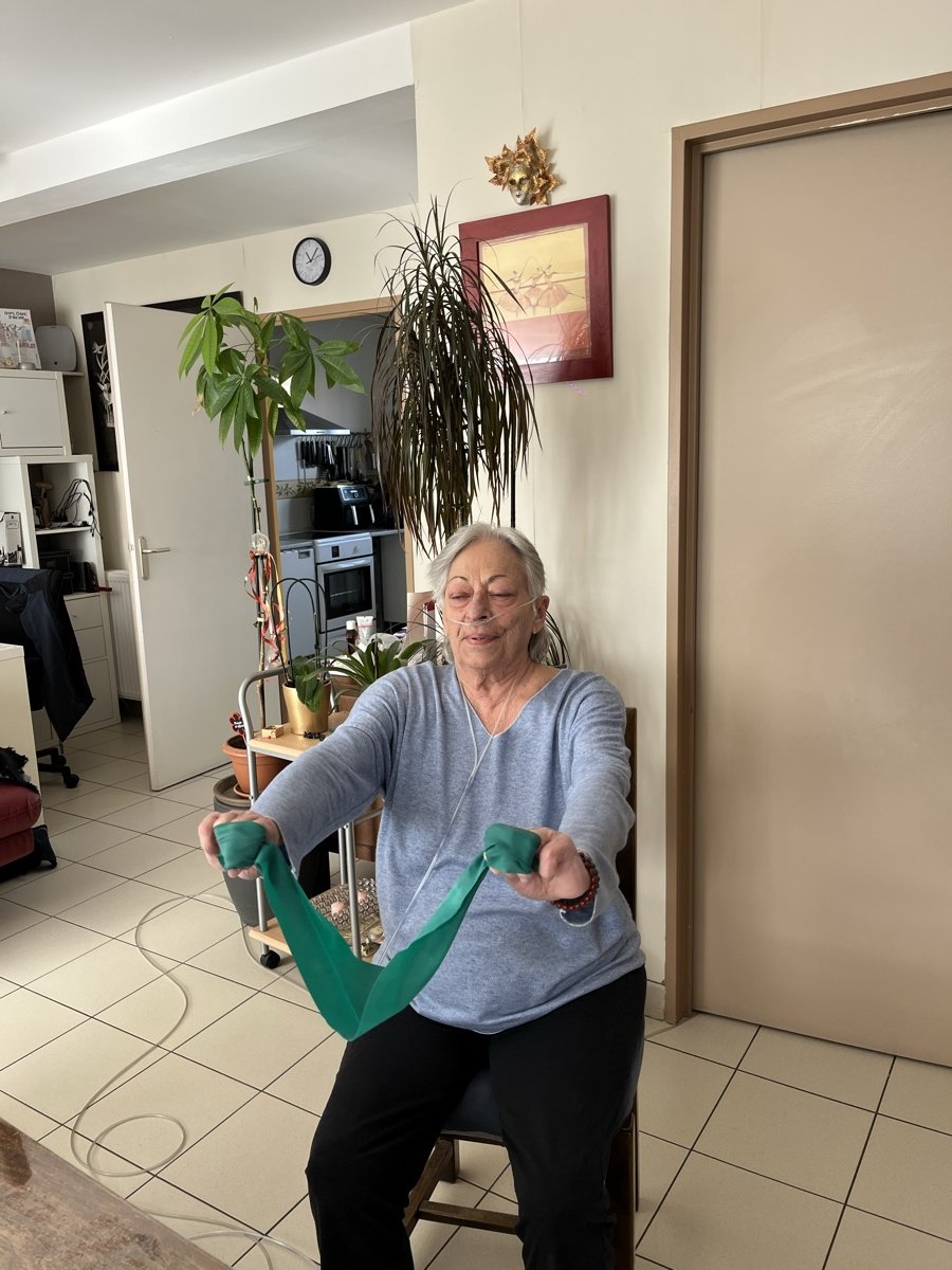 Patiente réalisant un exercice avec élastique lors d'une séance d'activité physique adaptée